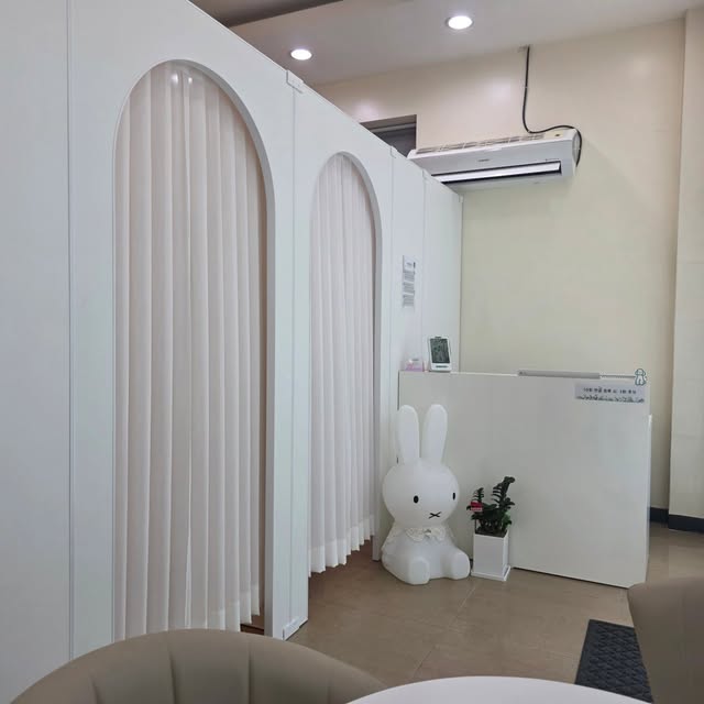 흰 아치형 커튼으로 나뉜 관리실과 토끼 모양 조명